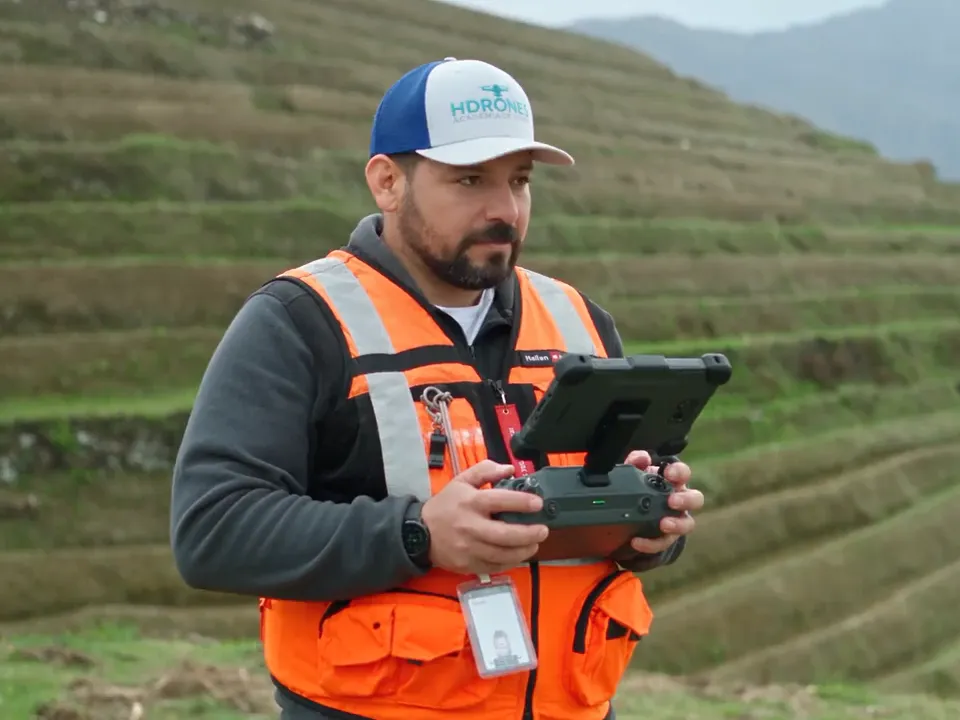 Instructor de la academia con el radiocontrol de un dron en una práctica de vuelo